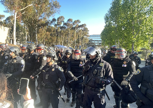 Figure 73: As students were held in the Price Center, protesters gathered on Library Walk, which was barricaded and blocked by police in riot gear. Image credit: Anonymous