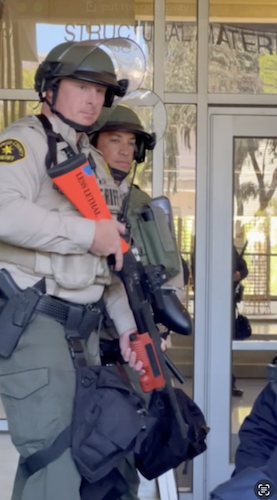 Figure 75: As police pointed live weapons at protesters outside Price Center, they chanted 'put the gun away!' Image credit: Anonymous