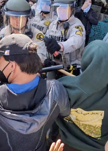 Figure 77: Police pepper spray students and Imam Taha, deploying the toxin just inches from their faces. Image credit: Anonymous